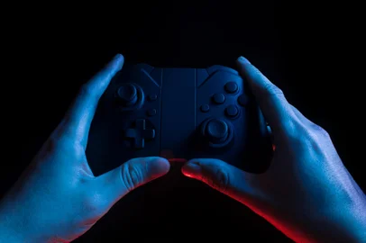 gamer boy with hand holding the joystick controller electronic for playing game with online network connection  technology device in esport tournament challenge concept. Jogo, videogameFonte: 301450832<!-- NICAID(14739060) -->