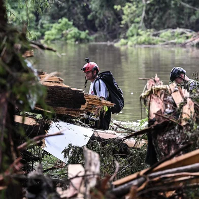 Members of a search and rescue team look for people near Camp Mystic, the site of where at least 20 girls went missing after flash flooding in Hunt, Texas, on July 5, 2025. Rescuers were on Saturday searching for more than 20 girls missing from a riverside summer camp in the US state of Texas, after torrential rains caused devastating flooding that killed at least 27 people -- with more rain on the way. "So far, we've evacuated over 850 uninjured people, eight injured people and have recovered 27 deceased fatalities at this time. Of these 27, 18 are adults, nine are children," said Kerr Country Sheriff Larry Leitha on July 5. (Photo by RONALDO SCHEMIDT / AFP)<!-- NICAID(16074092) -->