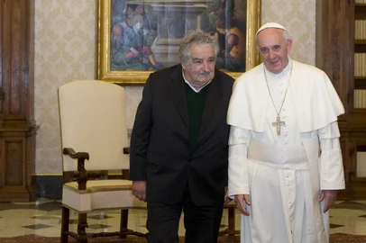 Pope Francis (R) walks with Uruguay's President Jose Mujica during a private audience in the pontiff's library at the Vatican on June 1, 2013.  AFP PHOTO / POOL / ALESSANDRA TARANTINO (Photo by ALESSANDRA TARANTINO / POOL / AFP)<!-- NICAID(16021707) -->