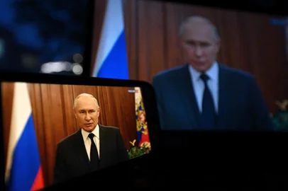 This photograph shows Russias President Vladimir Putin, seen on a smartphone screen and a laptop screen, addressing the nation in Moscow, on June 26, 2023. Russian President Vladimir Putin said on June 26, 2023 that he gave an order to avoid bloodshed during an armed rebellion over the weekend that rattled his rule, saying the West and Kyiv wanted Russians to "kill each other" and thanking citizens for their "patriotism." (Photo by NATALIA KOLESNIKOVA / AFP)<!-- NICAID(15466940) -->
