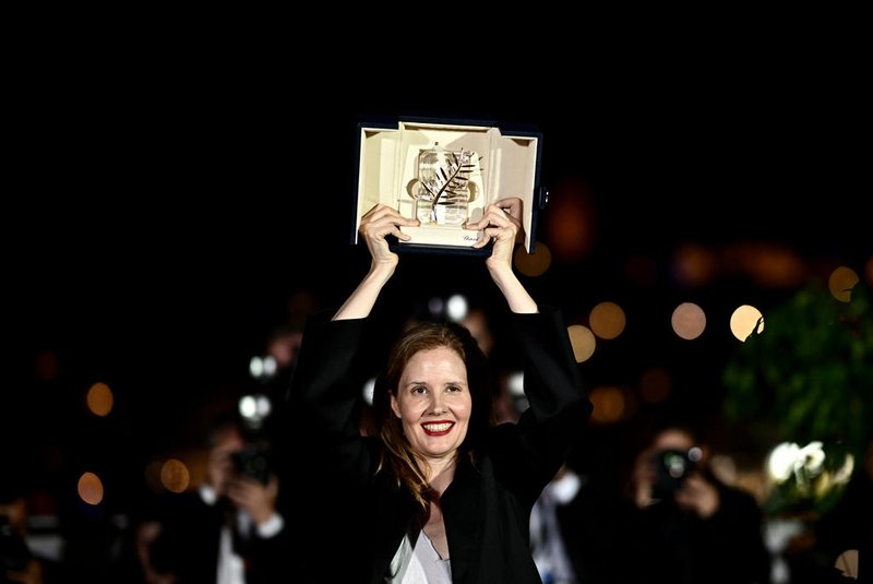 French director Justine Triet poses with her trophy during a photocall after she won the Palme d'Or for the film "Anatomie d'une Chute" (Anatomy of a Fall) during the closing ceremony of the 76th edition of the Cannes Film Festival in Cannes, southern France, on May 27, 2023. (Photo by LOIC VENANCE / AFP)<!-- NICAID(15440336) -->