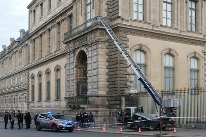 French police officers stand next to a furniture elevator used by robbers to enter the Louvre Museum, on Quai Francois Mitterrand, in Paris on October 19, 2025. Robbers broke in to the Louvre and fled with jewellery on October 19, 2025 morning, a source close to the case said, adding that its value was still being evaluated. A police source said an unknown number of thieves arrived on a scooter armed with small chainsaws and used a goods lift to reach the room they were targeting. (Photo by Dimitar DILKOFF / AFP)<!-- NICAID(16149422) -->