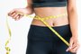 Close up shot woman with slim body measuring torsoClose up shot of woman with slim body measuring her waistline and torso. Healthy nutrition and weight losing concept.Fonte: 233714604<!-- NICAID(14789585) -->
