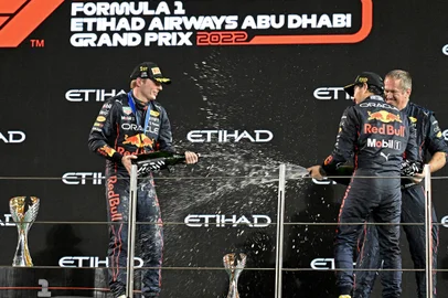 Red Bull's Dutch driver Max Verstappen (L), Red Bull's Mexican driver Sergio Perez (2nd-R) and Red Bull's Trackside Infrastructure Group Leader Olaf Janssen celebrate on the podium after the Abu Dhabi Formula One Grand Prix at the Yas Marina Circuit in the Emirati city of Abu Dhabi on November 20, 2022. (Photo by Karim Sahib / AFP)Editoria: SPOLocal: Abu DhabiIndexador: KARIM SAHIBSecao: motor racingFonte: AFPFotógrafo: STF<!-- NICAID(15270770) -->
