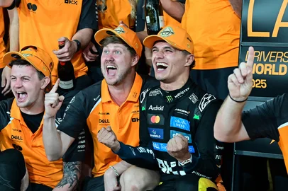 World champion and race third-placed McLaren's British driver Lando Norris (C-R) celebrates with his team at the end of the Abu Dhabi Formula One Grand Prix at the Yas Marina Circuit in Abu Dhabi on December 7, 2025. (Photo by GIUSEPPE CACACE / AFP)<!-- NICAID(16182724) -->