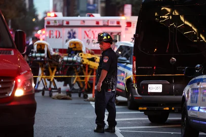 A firefighter stands near emergency vehicles as police respond to a nearby shooting incident in the Midtown Manhattan neighborhood of New York on July 28, 2025. Police swarmed Midtown Manhattan on Monday as the mayor of New York City said there was "an active shooter investigation" amid reports a police officer had been struck. New York City police commissioner Jessica Tisch said that the gunman, who had been on the loose in the busy Midtown district of Manhattan, had been "neutralized." (Photo by CHARLY TRIBALLEAU / AFP)Editoria: CLJLocal: New YorkIndexador: CHARLY TRIBALLEAUSecao: policeFonte: AFPFotógrafo: STF<!-- NICAID(16089840) -->