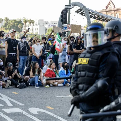 Protesters clash with law enforcement in the streets surrounding the federal building during a protest following federal immigration operations in Los Angeles, California, on June 8, 2025. Demonstrators torched cars and scuffled with security forces in Los Angeles on June 8, as police kept protestors away from the National Guard troops President Donald Trump sent to the streets of the second biggest US city. (Photo by RINGO CHIU / AFP)<!-- NICAID(16055449) -->