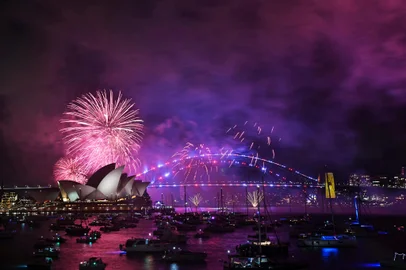 The "family fireworks" light up the Opera House and the Sydney Harbour Bridge, three hours ahead of the main show at midnight in Sydney on New Year's Eve on December 31, 2024. (Photo by Saeed KHAN / AFP)Editoria: LIFLocal: SydneyIndexador: SAEED KHANSecao: public holidayFonte: AFPFotógrafo: STF<!-- NICAID(15944996) -->
