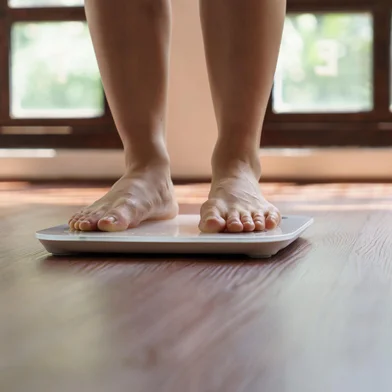Fat diet and scale feet standing on electronic scales for weight control. Measurement instrument in kilogram for a diet control.Fonte: 657229185<!-- NICAID(15833944) -->