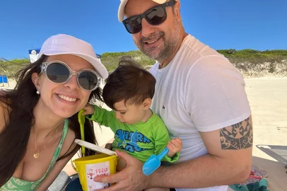 Kelly Matos / Arquivo Pessoal Kelly, Gabardo e o filho Praia do Rosa , em SC.<!-- NICAID(16187789) -->