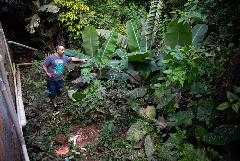 Na foto: Arleu, tio do menino Luís, mostra o local do acidente  os fundos de casa. PORTO ALEGRE, RS, BRASIL, 30.11.2023:  Luis Antonio, de 8 anos, morreu ao cair em um buraco alagado, aos fundos da casa da família, no bairro Aparício Borges, zona Leste da capital, na sexta-feira passada. Um bueiro entupiu e impediu a saída da água do córrego. Antes, havia um muro e uma cerca protegendo a casa, mas uma enchente em 2015 derrubou a estrutura. Foto: Camila Hermes/Agencia RBS<!-- NICAID(15613511) -->