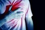 man, guy in a white t shirt on a black background in a blue color hold hands on his heart, heart atack, severe heartache, chest  myocardial infarctionAtaque cardíaco, infarto. Foto: EVGENIY / stock.adobe.comFonte: 174538976<!-- NICAID(15328755) -->