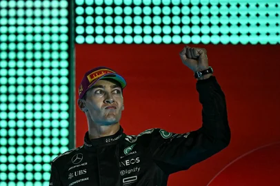 First-placed Mercedes' British driver George Russell celebrates on the podium after the Formula One Singapore Grand Prix night race at the Marina Bay Street Circuit in Singapore on October 5, 2025. (Photo by Lillian SUWANRUMPHA / AFP)<!-- NICAID(16146584) -->