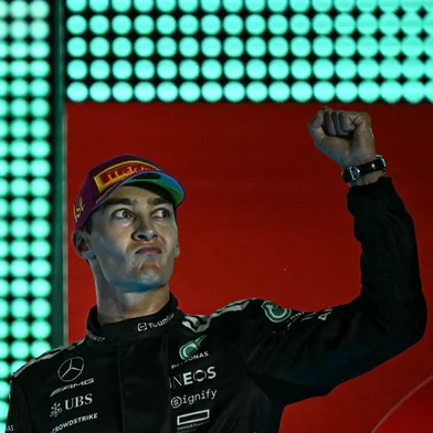 First-placed Mercedes' British driver George Russell celebrates on the podium after the Formula One Singapore Grand Prix night race at the Marina Bay Street Circuit in Singapore on October 5, 2025. (Photo by Lillian SUWANRUMPHA / AFP)<!-- NICAID(16146584) -->