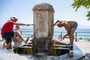 People cool off at a water fountain in Messina, on the island of Sicily, during a heat wave on July 16, 2023. Tens of millions of people were battling dangerously high temperatures around the world on July 16, 2023, as record heat forecasts hung over parts of the United States, Europe and Asia, in the latest example of the threat from global warming. (Photo by GIOVANNI ISOLINO / AFP)Editoria: WEALocal: MessinaIndexador: GIOVANNI ISOLINOSecao: reportFonte: AFPFotógrafo: STR<!-- NICAID(15484078) -->