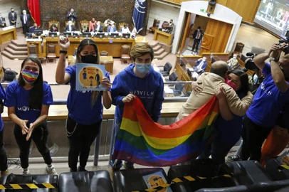 Members of different social movements celebrate in the Senate after the passing of a bill to legalize same-sex marriage in Chile, at the National Congress in Valparaiso, Chile, on December 7, 2021. - Chile's congress on Tuesday approved a long-awaited bill to legalize same-sex marriage, joining just a handful of countries in majority Catholic Latin America with similar laws. The measure has the support of President Sebastian Pinera, who must sign it into law, and will also enable married same-sex couples to adopt children. (Photo by Dedvi MISSENE / AFP)Editoria: POLLocal: ValparaísoIndexador: DEDVI MISSENESecao: justice and rightsFonte: AFPFotógrafo: STR<!-- NICAID(14961916) -->