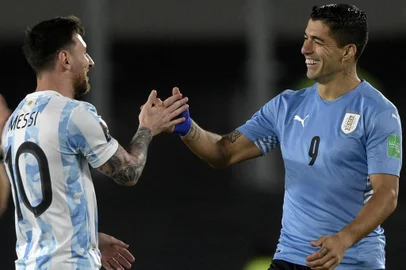 (FILES) Argentina's Lionel Messi (L) greets Uruguay's Luis Suarez before the start of the South American qualification football match for the FIFA World Cup Qatar 2022, at the Monumental stadium in Buenos Aires, on October 10, 2021. With retirement on the horizon, the Copa America 2024 may be the last for some of the greatest stars of South American football, including legends such as Lionel Messi, Luis Suarez, James Rodriguez, and Angel Di Maria. (Photo by Juan Mabromata / AFP)<!-- NICAID(15790980) -->