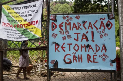 Porto Alegre, RS, Brasil, 27-12-2022: Faixas e cartazes em frente à ocupação. Indígenas kaingang e xokleng ocupam área no Morro Santana que consideram território ancestral sagrado em movimento denominado Retomada Multiétnica Gãh Ré. Eles reivindicam o direito à área, ameaçada pela especulação imobiliária. A cacica kaingang Gah Té Iracema Nascimento fez greve de fome por alguns dias para pressionar a reversão de uma reintegração de posse do imóvel ocupado. Foto: Mateus Bruxel / Agência RBSIndexador: Mateus Bruxel<!-- NICAID(15305787) -->