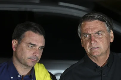Brazilian President and re-election candidate Jair Bolsonaro (R) speaks next to his son Flavio after learning the results of the legislative and presidential election next to his son Flavio Bolsonaro (L) in Brasilia, on October 2, 2022. - Brazil's bitterly divisive presidential election will go to a runoff on October 30, electoral authorities said Sunday, as incumbent Jair Bolsonaro beat expectations to finish a relatively close second to front-runner Luiz Inacio Lula da Silva. Lula, the veteran leftist seeking a presidential comeback, had 48.1 percent of the vote to 43.5 percent for the far-right President, with 98 percent of polling stations reporting, according to official from the Superior Electoral Tribunal. (Photo by EVARISTO SA / AFP)Editoria: POLLocal: BrasíliaIndexador: EVARISTO SASecao: electionFonte: AFPFotógrafo: STF<!-- NICAID(15224699) -->