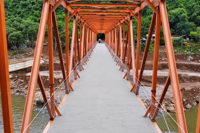 previsão de secagem e cura do concreto é de 21 dias./ Durante esse período será feita as cabeceiras para acesso à ponte tanto no lado de Farroupilha quanto no sentido de Nova Roma do Sul./ A nova ponte de ferro é quase dois metros mais alta que aquela que foi destruída pela força do Rio das Antas em setembro./ E por isso será preciso levantar o acesso./ A liberação do trânsito depende de um laudo realizado pela empresa Concresul que vai monitorar a cura do concreto semanalmente./ Antes disso é preciso instalar o guarda corpo e realizar a pintura da pista./ O presidente da Associação Amigos de Nova Roma do Sul, Tranquilo Tessaro planeja também idealizar a iluminação antes da inauguração prevista para o domingo, dia 21 de janeiro.//<!-- NICAID(15638012) -->