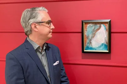A handout photo released on June 15, 2021, courtesy of the auction house Cowley Abbott shows Canadian Art Specialist Rob Cowley looking at a painting by British pop icon David Bowie in Toronto, Canada. - A painting by British pop icon David Bowie recently discovered at a Canadian store that resells donated goods had frantic bidders lining up for a chance to own it June 15, 2021. (Photo by Handout / Cowley Abbott / AFP) / RESTRICTED TO EDITORIAL USE - MANDATORY CREDIT "AFP PHOTO /Cowley Abbott " - NO MARKETING - NO ADVERTISING CAMPAIGNS - DISTRIBUTED AS A SERVICE TO CLIENTS<!-- NICAID(14810171) -->