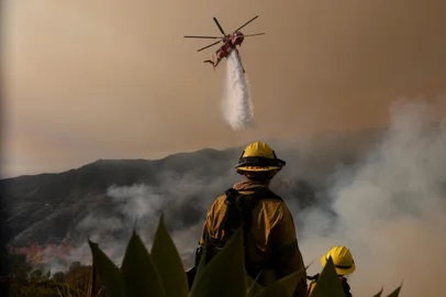 LOS ANGELES, CALIFORNIA - JANUARY 11: A firefighting helicopter drops water on the Palisades Fire on January 10, 2025 in Los Angeles, California. The Palisades fire had grown to over 22,000 acres and has destroyed thousands of homes. The fire is currently 11 percent contained.   Justin Sullivan/Getty Images/AFP (Photo by JUSTIN SULLIVAN / GETTY IMAGES NORTH AMERICA / Getty Images via AFP)<!-- NICAID(15951968) -->