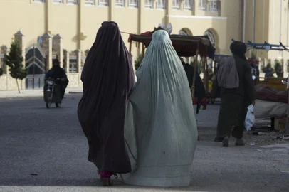 Burqa-clad women walk along a street in Kandahar on May 7, 2022. - The Taliban on May 7 imposed some of the harshest restrictions on Afghanistan's women since they seized power, ordering them to cover fully in public, ideally with the traditional burqa. (Photo by Javed TANVEER / AFP)<!-- NICAID(15090005) -->