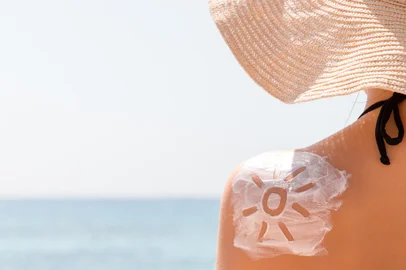 Sunscreen lotion in sun shape on tanned woman's shoulder*A PEDIDO DE DANIEL FEIX* Protetor solar aplicado - Foto: sosiukin/stock.adobe.comIndexador: SosiukinFonte: 269154162<!-- NICAID(15294982) -->