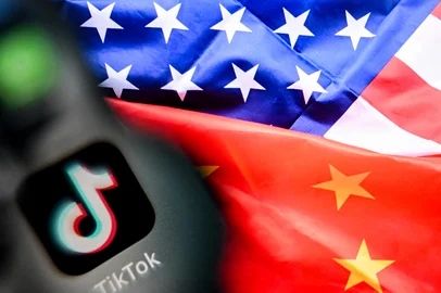 A photo taken on April 10, 2025 shows the Chinese social networking service TikTok's logo on a smartphone screen (L) and US' and China flags combo illustration on a laptop screen in Frankfurt am Main, western Germany. US President Donald Trump said on April 6, 2025 that China would have agreed to a deal on the sale of TikTok if it were not for the tariffs imposed by Washington on Beijing last week. (Photo by Kirill KUDRYAVTSEV / AFP)Editoria: FINLocal: FrankfurtIndexador: KIRILL KUDRYAVTSEVSecao: computing and information technoFonte: AFPFotógrafo: STF<!-- NICAID(16124864) -->
