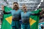 Brazil's Rebeca Andrade (L) and Flavia Saraiva celebrate after winning the gold and silver medals respectively in the artistic gymnastics women's balance beam final during the Pan American Games Santiago 2023 at the Team Sports Centre in the National Stadium Sports Park in Santiago on October 25, 2023. (Photo by MARTIN BERNETTI / AFP)Editoria: SPOLocal: SantiagoIndexador: MARTIN BERNETTISecao: gymnasticsFonte: AFPFotógrafo: STF<!-- NICAID(15579258) -->