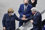 The current President of the Bundesrat (upper house of parliament) Reiner Haseloff (C) looks on as German Chancellor Angela Merkel (L) fist bumps Hesse's State Premier Volker Bouffier (R) at the Bundestag (lower house of parliament) on December 18, 2020 in Berlin. (Photo by John MACDOUGALL / AFP)