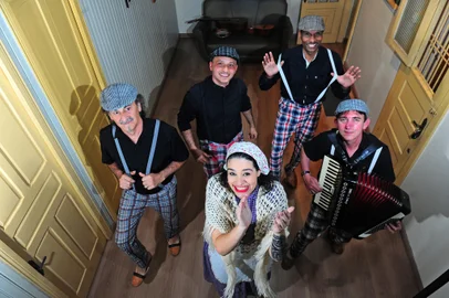 CAXIAS DO SUL, RS, BRASIL, 16/08/2023. Integrantes d’Os Colonos Zo Scarpon comentam sobre a trajetória do grupo, que está prestes a celebrar 20 anos dedicados ao repertório e à cultura imigrante italiana, em Caxias. Na foto: atrás: Ederton Pezzi (bateria) e Claudio Gilmar da Silva (guitarra e violão). Na frente: Luis Antônio Rossa (baixo), Luiza Pezzi (cantora) e Denival Silveira dos Santos (acordeon). (Porthus Junior/Agência RBS)Indexador:                                 <!-- NICAID(15513026) -->