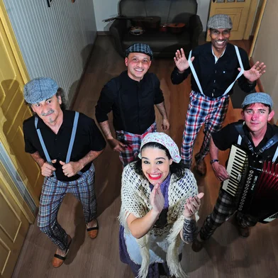 CAXIAS DO SUL, RS, BRASIL, 16/08/2023. Integrantes d’Os Colonos Zo Scarpon comentam sobre a trajetória do grupo, que está prestes a celebrar 20 anos dedicados ao repertório e à cultura imigrante italiana, em Caxias. Na foto: atrás: Ederton Pezzi (bateria) e Claudio Gilmar da Silva (guitarra e violão). Na frente: Luis Antônio Rossa (baixo), Luiza Pezzi (cantora) e Denival Silveira dos Santos (acordeon). (Porthus Junior/Agência RBS)Indexador:                                 <!-- NICAID(15513026) -->
