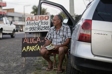 TORRES, RS, BRASIL, 17-01-2026: Júlio de Mesquita Bernardino, 59 anos, ao lado da placa em que oferece sua casa para alugar. Moradores de Torres, no Litoral Norte, aguardam à beira da estrada que dá acesso à cidade com placas para alugar suas próprias casas durante a temporada de verão. A prática, tradicional na cidade, leva famílias a deixarem temporariamente suas residências nesse período, algumas passam a viver na casa de parentes ou em pequenos cômodos anexos, para obter renda extra com veranistas que chegam de última hora. Foto: Mateus Bruxel/Agência RBSIndexador: MATEUS BRUXEL<!-- NICAID(16207488) -->