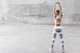 Fitness sport woman em moda sportwear fazendo exercício de alongamento sobre parede cinzaIndexador: Alena OzerovaFonte: 250565185<!-- NICAID(14316642) -->
