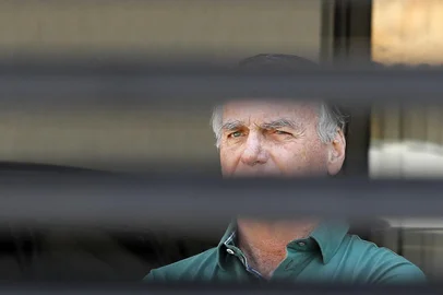Former Brazilian President Jair Bolsonaro stands at the garage of his residence in Brasilia on September 11, 2025. A Brazilian judge on September 10 returned the first not-guilty vote in the coup-plotting trial of former president Jair Bolsonaro, shifting all eyes on the last two of his colleagues left to vote following two guilty findings. The 70-year-old far-right ex-leader risks a prison sentence of more than 40 years if found guilty of seeking to claw back power after his defeat in 2022 elections to leftist Luiz Inacio Lula da Silva (Photo by Sergio Lima / AFP)<!-- NICAID(16122040) -->