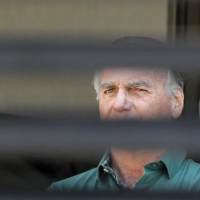 Former Brazilian President Jair Bolsonaro stands at the garage of his residence in Brasilia on September 11, 2025. A Brazilian judge on September 10 returned the first not-guilty vote in the coup-plotting trial of former president Jair Bolsonaro, shifting all eyes on the last two of his colleagues left to vote following two guilty findings. The 70-year-old far-right ex-leader risks a prison sentence of more than 40 years if found guilty of seeking to claw back power after his defeat in 2022 elections to leftist Luiz Inacio Lula da Silva (Photo by Sergio Lima / AFP)<!-- NICAID(16122040) -->