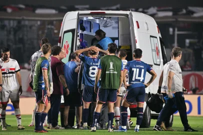 Nacional's defender Juan Manuel Izquierdo (covered) is carried into an ambulance after fainting during the Copa Libertadores round of 16 second leg football match between Brazil's Sao Paulo and Uruguay's Nacional at the MorumBIS stadium in Sao Paulo, Brazil, on August 22, 2024. (Photo by NELSON ALMEIDA / AFP)<!-- NICAID(15847411) -->