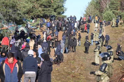 A picture taken on November 9, 2021 shows migrants at the Belarusian-Polish border in the Grodno region. - Poland and Belarus squared off on November 9 over thousands of migrants aiming to enter EU member Poland, with Warsaw saying the wave threatened the security of the entire bloc. Minsk warned against "provocations" on the border, where armed troops from both countries are deployed amid escalating tensions. Trapped between the rhetoric are thousands of people, many escaping war and poverty in the Middle East, trying to survive outdoors in squalid conditions as temperatures dip toward freezing. (Photo by Leonid Shcheglov / BELTA / AFP) / Belarus OUT<!-- NICAID(14936152) -->