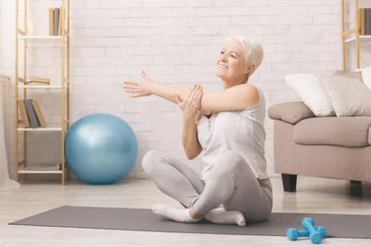 Positive sporty senior woman warming up at homePositive sporty senior woman warming up at home, panorama, free spaceIndexador: Konstantin PostumitenkoFonte: 327794759<!-- NICAID(14713518) -->