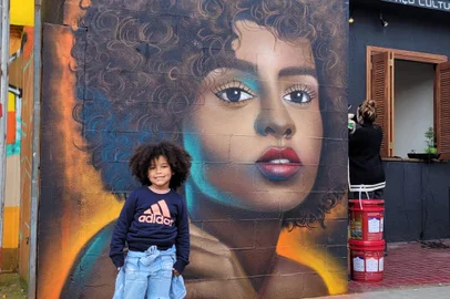 Menina Keisy Antonela da Rosa dos Santos, quatro anos, posa em frente ao grafite feito por Erick Citon, no muro do Vielas Espaço Cultural<!-- NICAID(15133604) -->