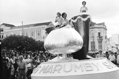 Studio Geremia / Arquivo Histórico Municipal João Spadari Adami,divulgação Carro alegórico da firma Kunz & Cia Ltda - Produtores dos Aperitivos Marumby (Bebidas Marumby), durante a passagem pela Av. Júlio de Castilhos, na Festa da Uva de 1961. No carro estão as jovens Luiza Wietshke, Terezinha Abibi e Yara Mattana.<!-- NICAID(16162182) -->