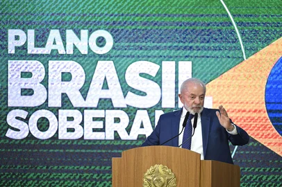 Brazil's President Luiz Inacio Lula da Silva gestures as he speaks during the signing of a decree with measures to mitigate the economic impact of the US government's increase of up to 50% in import tariffs on Brazilian products at the Planalto Palace in Brasília on August 13, 2025. Brazilian President Luiz Inacio Lula da Silva on Tuesday announced aid worth some $5.5 billion for companies hit by Donald Trump's trade tariffs, as part of a package of economic relief measures. (Photo by EVARISTO SA / AFP)<!-- NICAID(16100681) -->