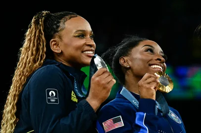 (LtoR) Second-placed Brazil's Rebeca Andrade, winner US' Simone Biles and third-placed US' Sunisa Lee pose for a selfie during the podium ceremony after the artistic gymnastics women's all around final during the Paris 2024 Olympic Games at the Bercy Arena in Paris, on August 1, 2024. (Photo by Loic VENANCE / AFP)<!-- NICAID(15830472) -->