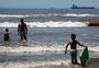 Mar calmo, temperatura alta e ausência de vento levam banhistas à beira da praia em Tramandaí
