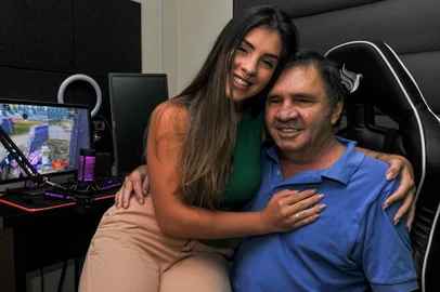 CAXIAS DO SUL, RS, BRASIL, 16/03/2023. Débora Macedo começou a fazer as lives depois que a mãe morreu e ela teve de largar o emprego para cuidar do pai, que ficou cego por conta da diabetes. Na foto, Débora Macedo e seu Pai Antônio Macedo(Neimar De Cesero/Agência RBS)Indexador: NEIMAR DE CESERO<!-- NICAID(15377307) -->