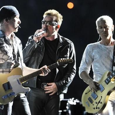 Bono (C), singer of the Irish rock band U2 performs on stage next to Adam Clayton (R) and The Edge during their "360° Tour" at the Commerzbank Arena in Frankfurt/Main, western Germany on August 10, 2010. AFP PHOTO / BORIS ROESSLER  GERMANY OUT<!-- NICAID(5476135) -->