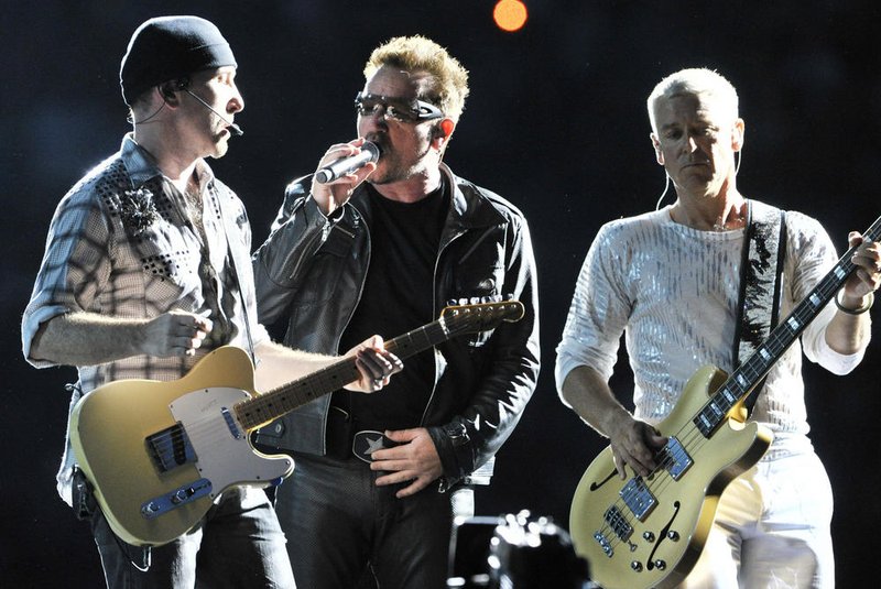 Bono (C), singer of the Irish rock band U2 performs on stage next to Adam Clayton (R) and The Edge during their "360° Tour" at the Commerzbank Arena in Frankfurt/Main, western Germany on August 10, 2010. AFP PHOTO / BORIS ROESSLER  GERMANY OUT<!-- NICAID(5476135) -->