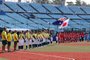 Australia (L) and Japan's (R) softball players listen to their national anthems prior to start the Tokyo 2020 Olympic Games softball opening round game between Australia and Japan at Fukushima Azuma Baseball Stadium in Fukushima, Japan, on July 21, 2021. (Photo by yuma Suguro / JIJI PRESS / AFP) / Japan OUTEditoria: SPOLocal: FukushimaIndexador: YUMA SUGUROSecao: softballFonte: JIJI PRESSFotógrafo: STR<!-- NICAID(14840453) -->