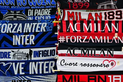 Inter Milan (L) and AC Milan (R) scalves are displayed at a vendors stand outside the stadium ahead of the Coppa Italia second leg semi-final football match between Inter Milan and AC Milan at the San Siro stadium in Milan on April 23, 2025. (Photo by Piero CRUCIATTI / AFP)<!-- NICAID(16022544) -->